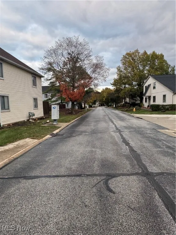 View of asphalt road featuring curbs and a residential view