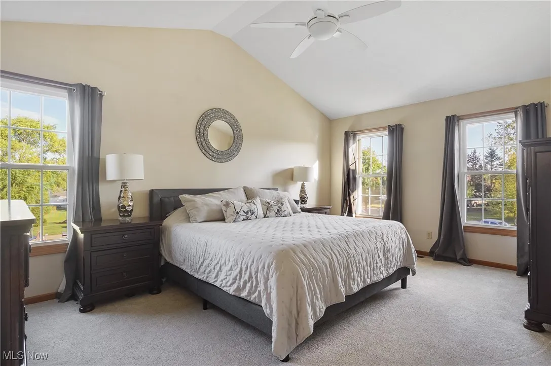 Bedroom with light carpet, lofted ceiling, and a ceiling fan
