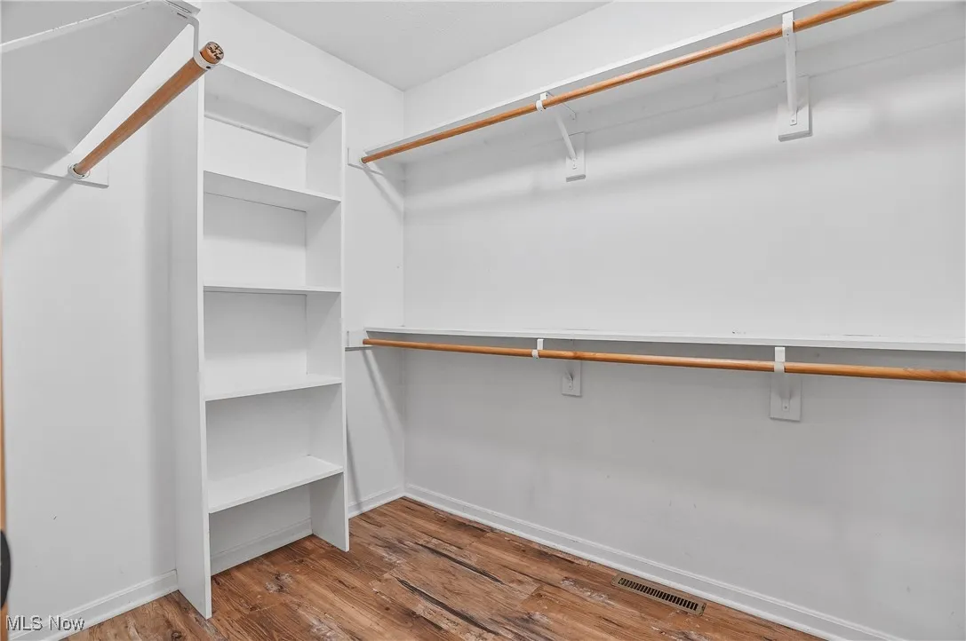 Walk in closet with light wood finished floors