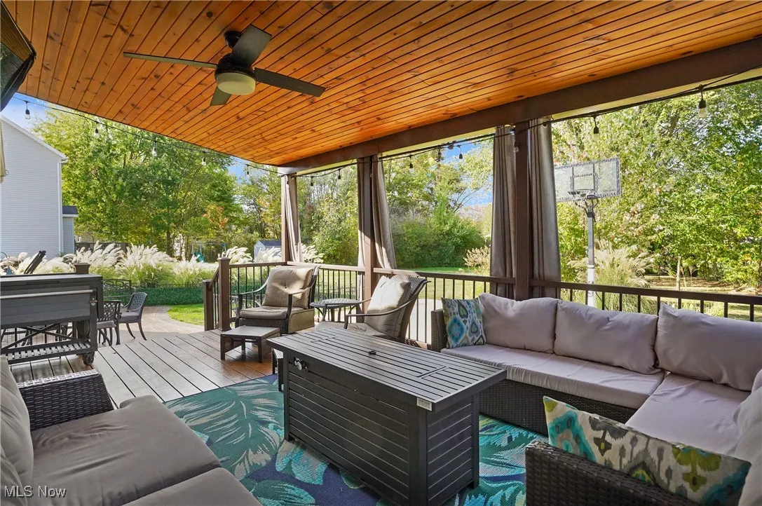 Sunroom / solarium with an outdoor hangout area, ceiling fan, and a wooden deck