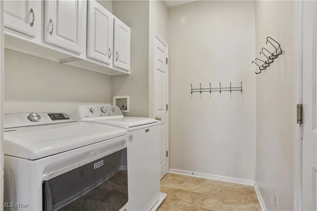 Laundry room featuring cabinet space and washer and clothes dryer