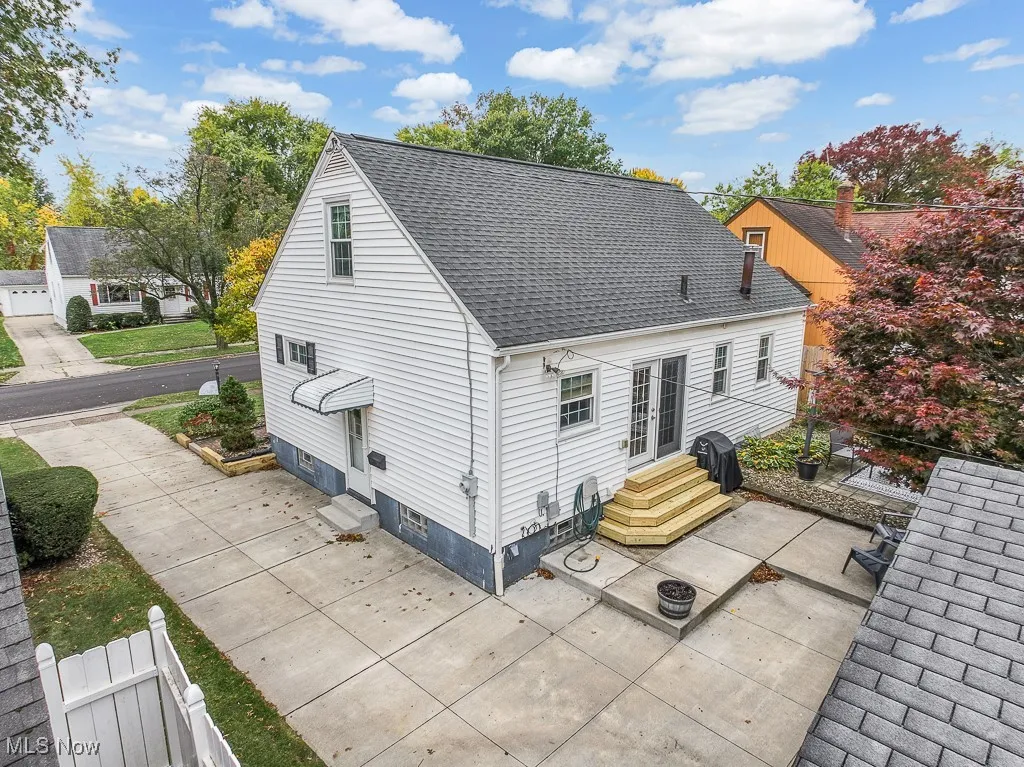 Rear view of house with a patio area, a shingled roof, and entry steps