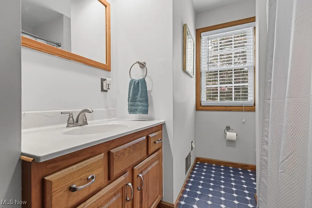 Full bath featuring curtained shower and vanity