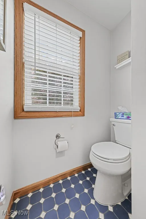 Half bath featuring baseboards and tile patterned floors