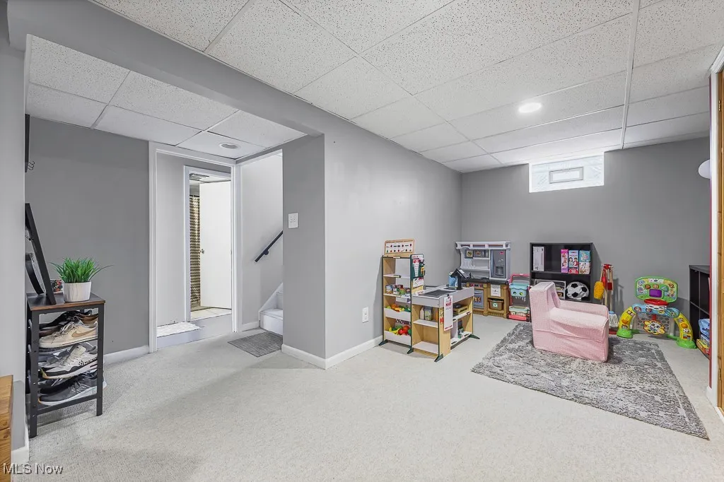 Rec room with light carpet and a paneled ceiling