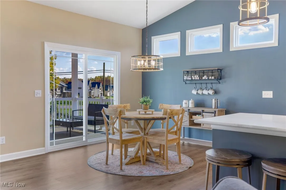 Dining area with lofted ceiling, hardwood floors, and a chandelier