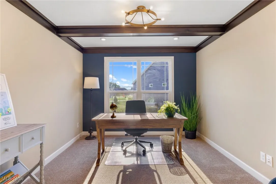 Office space featuring an inviting chandelier, light colored carpet, and beam ceiling