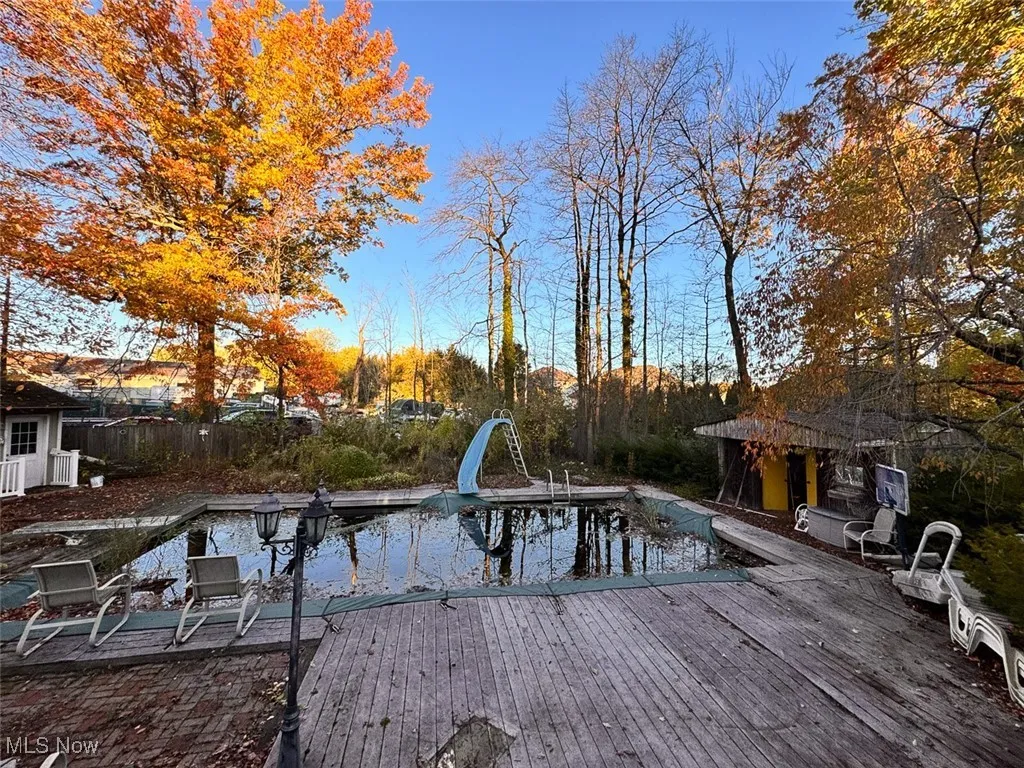 View of swimming pool with a water slide and an empty pool