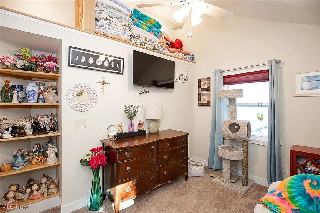 Bedroom featuring light carpet, lofted ceiling, and ceiling fan