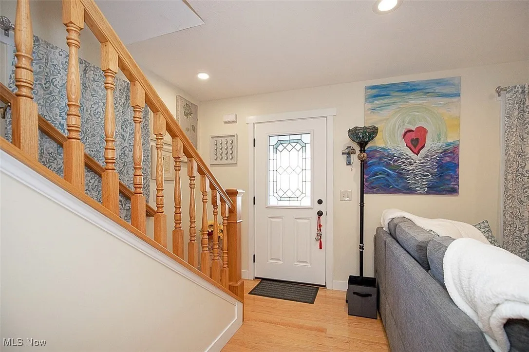 Entryway with maple wood floors, stairway, and recessed lighting