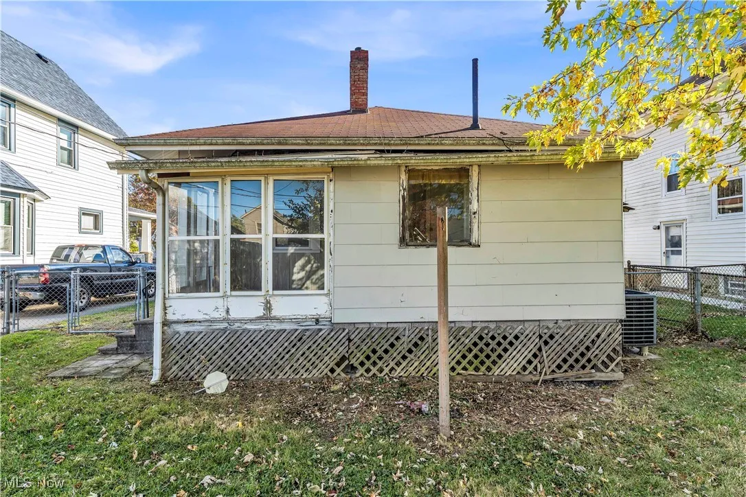 Back of property featuring a chimney and a gate