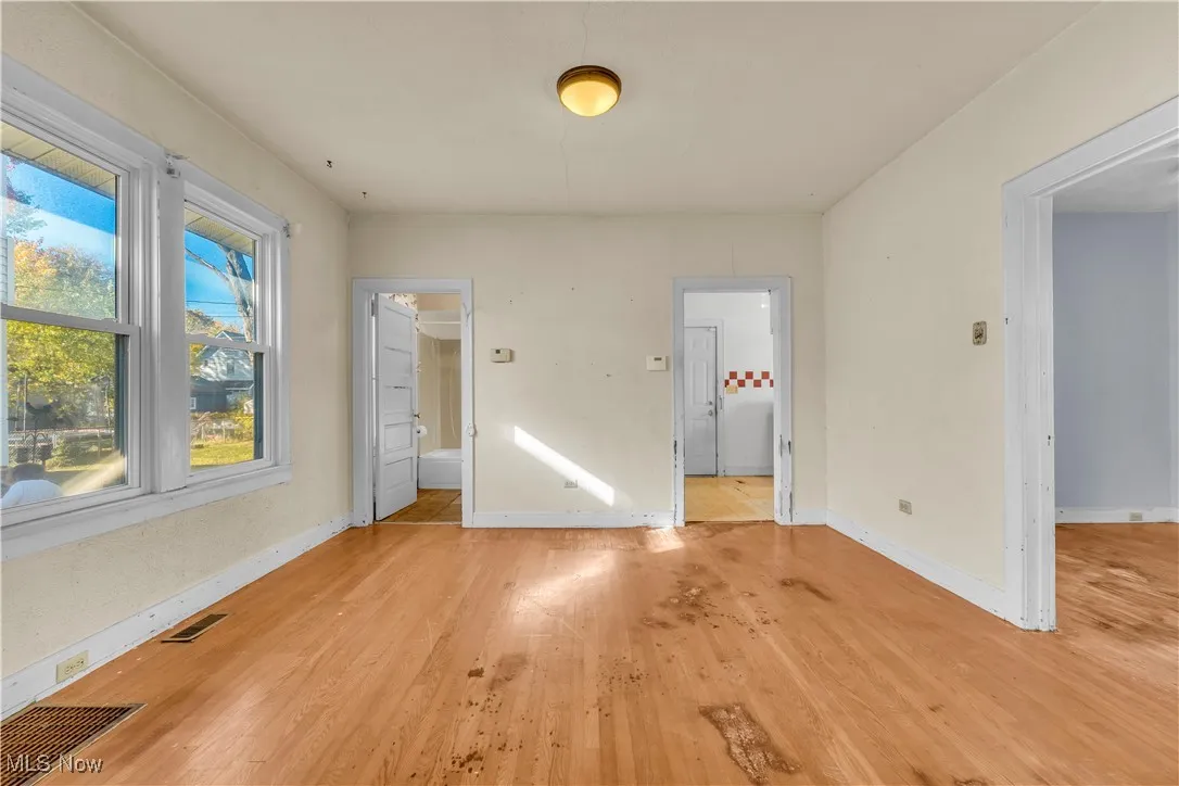 Unfurnished bedroom with wood finished floors and ensuite bath