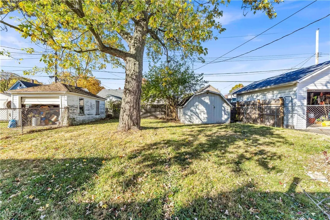 Fenced backyard featuring a shed