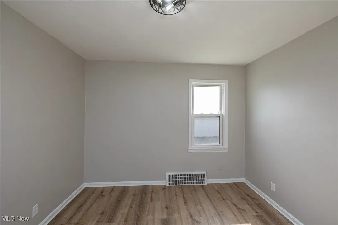 Unfurnished room with light wood-style flooring and baseboards