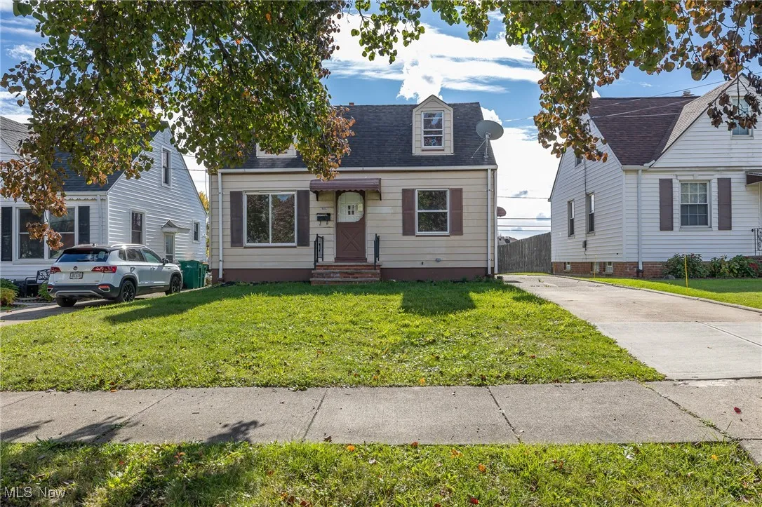 Cape cod-style house with roof with shingles and concrete driveway