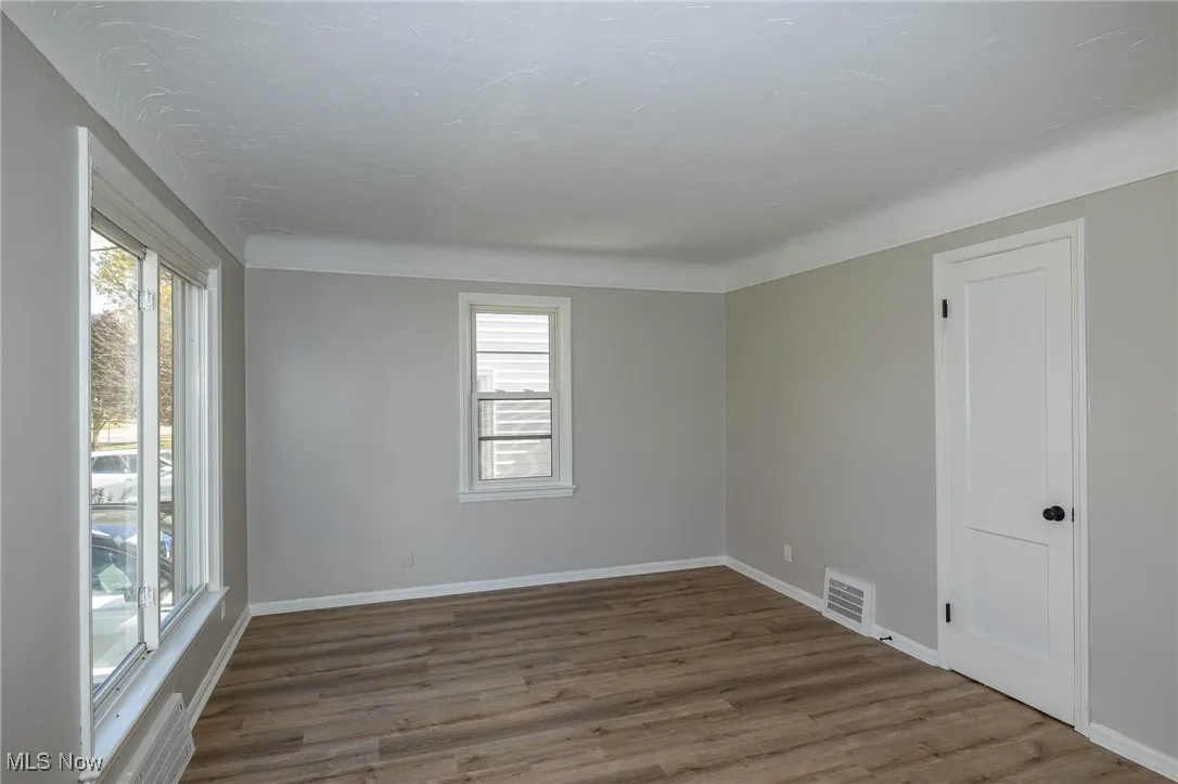 Empty room featuring wood finished floors and baseboards