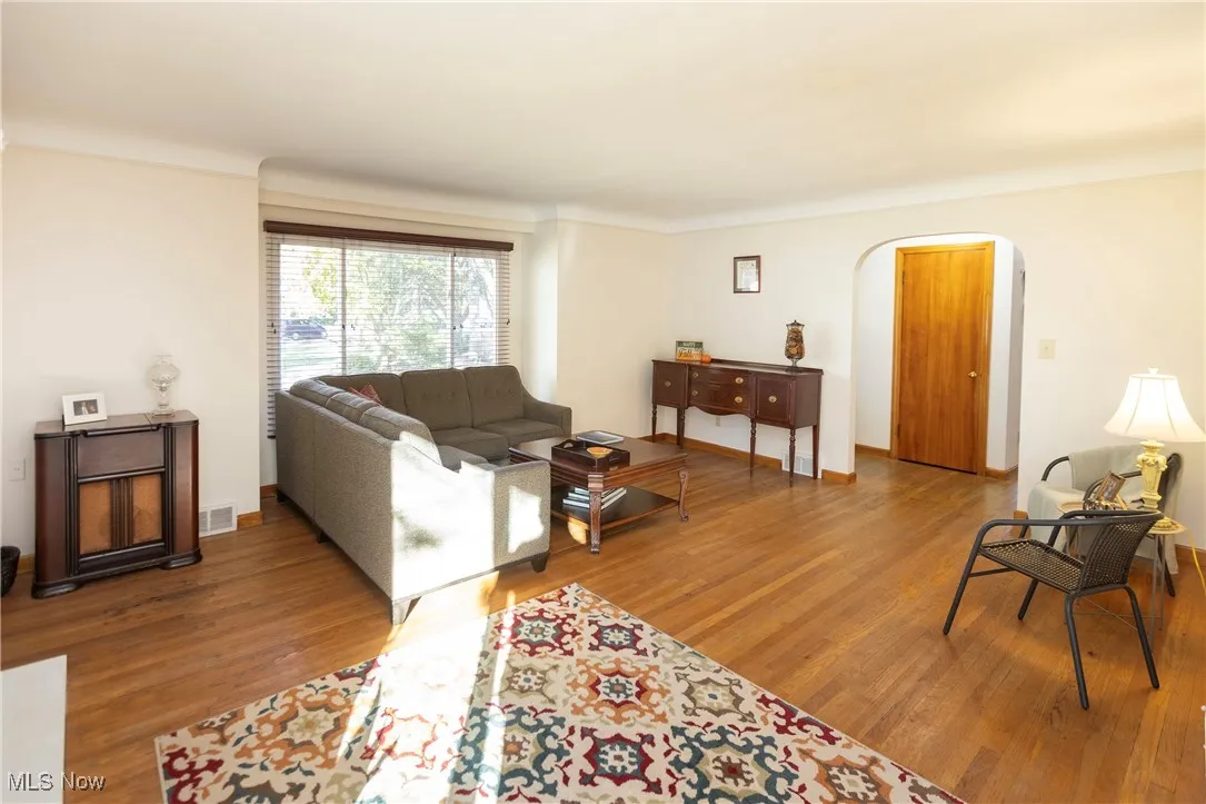 Living room featuring arched walkways and wood finished floors