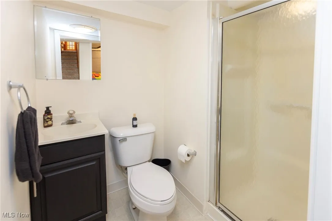 Full bathroom featuring vanity, a shower stall, and light tile patterned floors