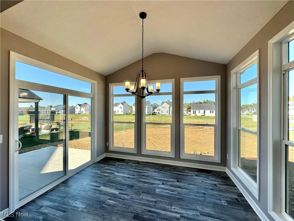 Unfurnished sunroom featuring a chandelier and vaulted ceiling