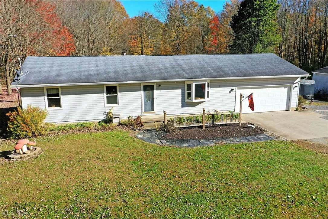 Ranch-style house with a front lawn, driveway, and roof with shingles