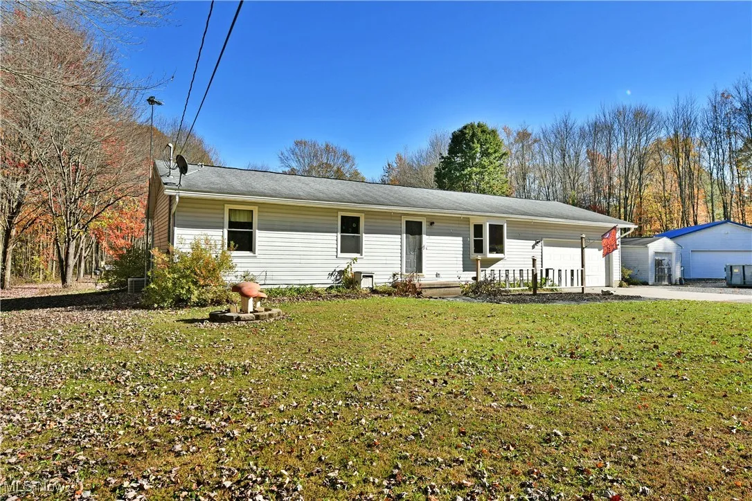 Ranch-style home featuring a front lawn and a detached garage