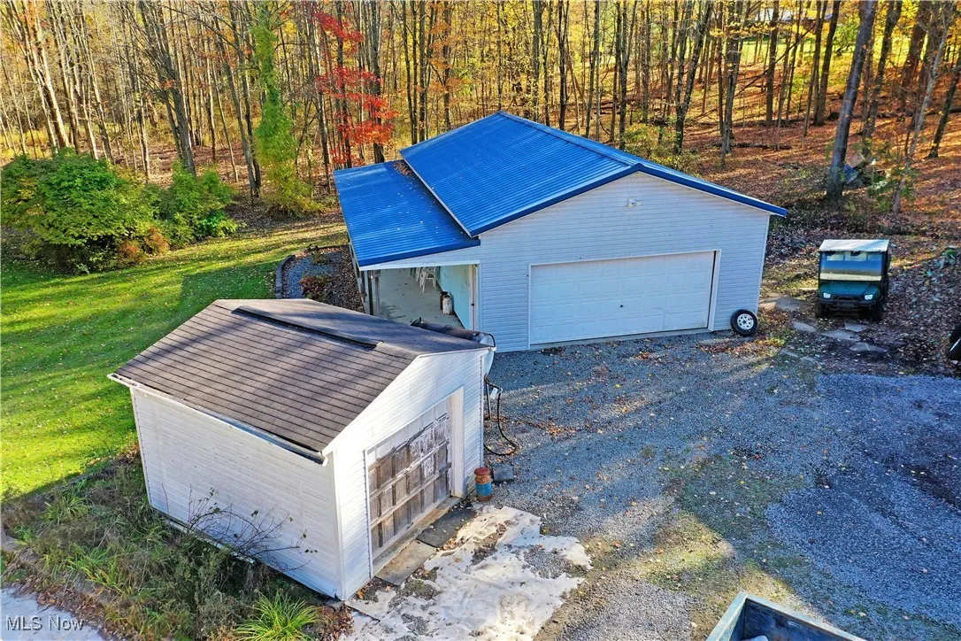 Garage with driveway and a view of trees