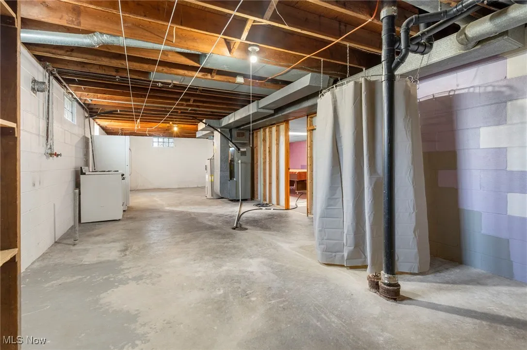 Basement featuring heating unit, freestanding refrigerator & stove