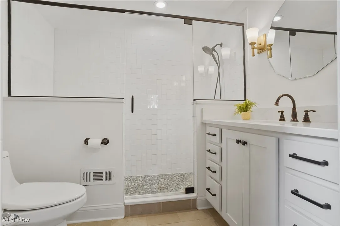Full bath featuring vanity, a shower stall, light tile patterned floors, and recessed lighting