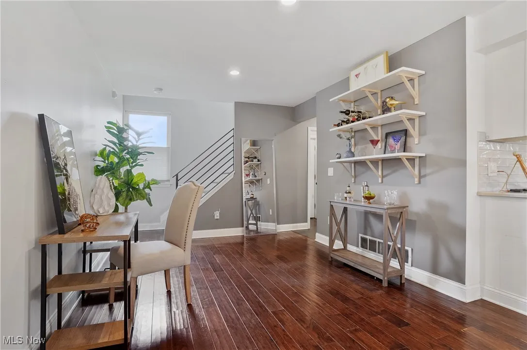 Office with dark wood-type flooring and recessed lighting