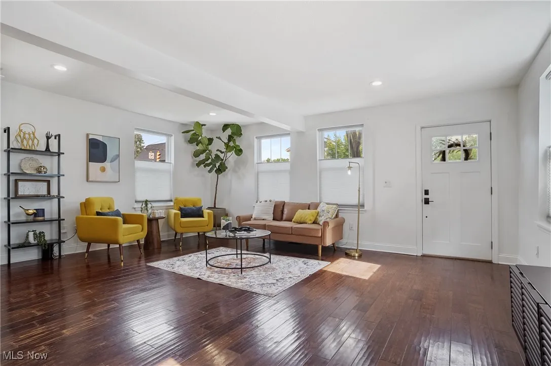Living area with healthy amount of natural light, dark wood-style floors, recessed lighting, and beamed ceiling