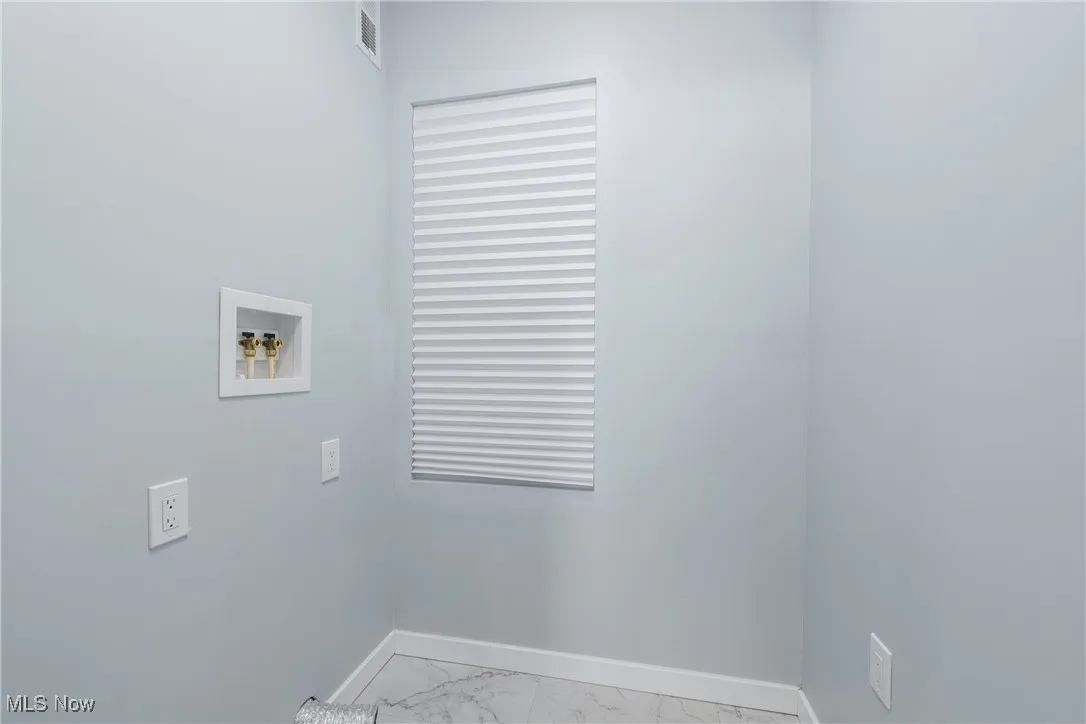 Washroom featuring visible vents, marble finish floor, washer hookup, baseboards, and laundry area