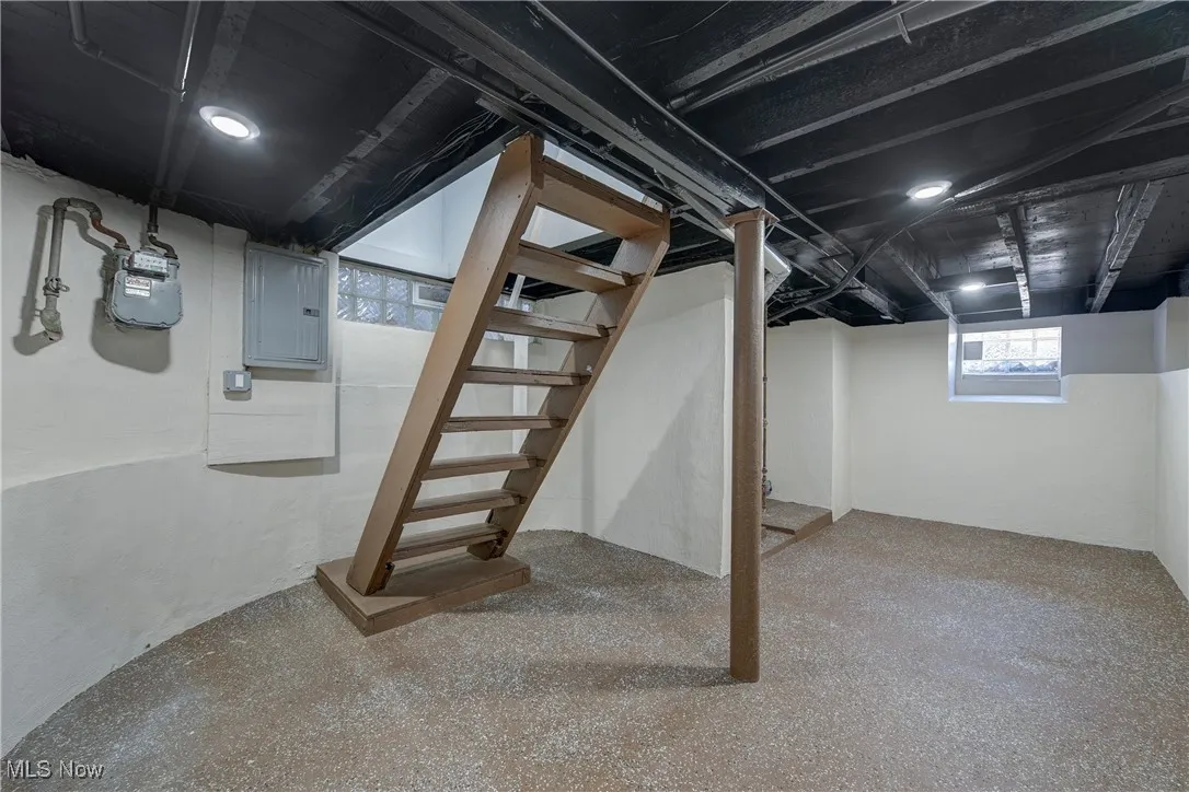 Basement with stairs and electric panel