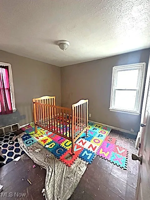 Bedroom with a textured ceiling and baseboards