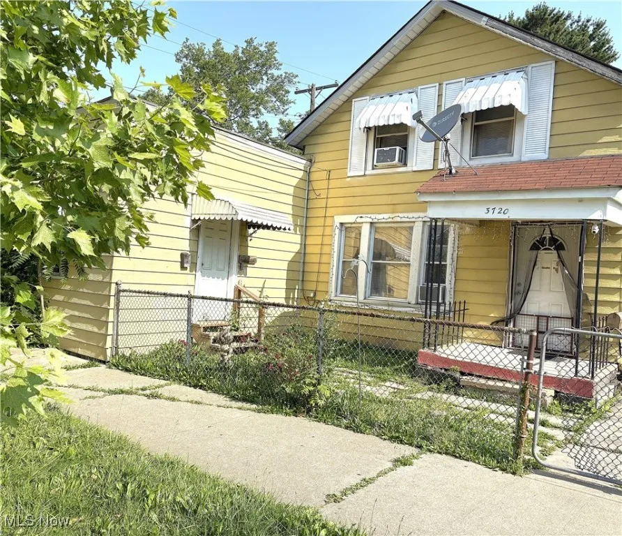 View of front facade with a fenced front yard and a gate
