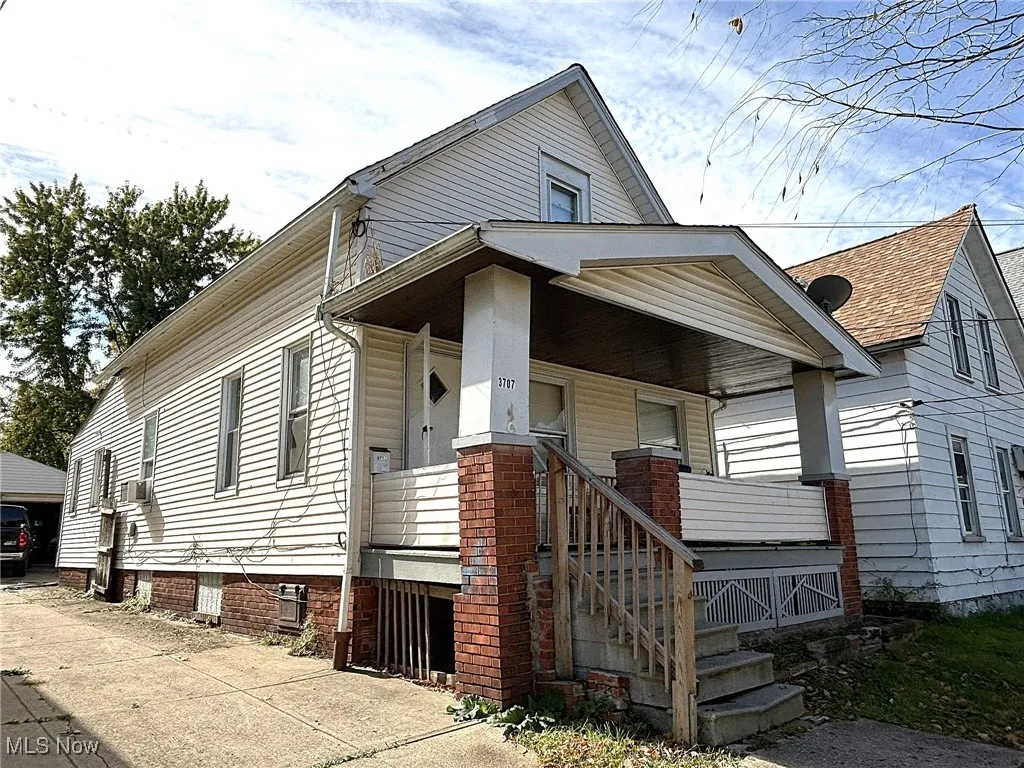 View of front of property with covered porch and a detached garage