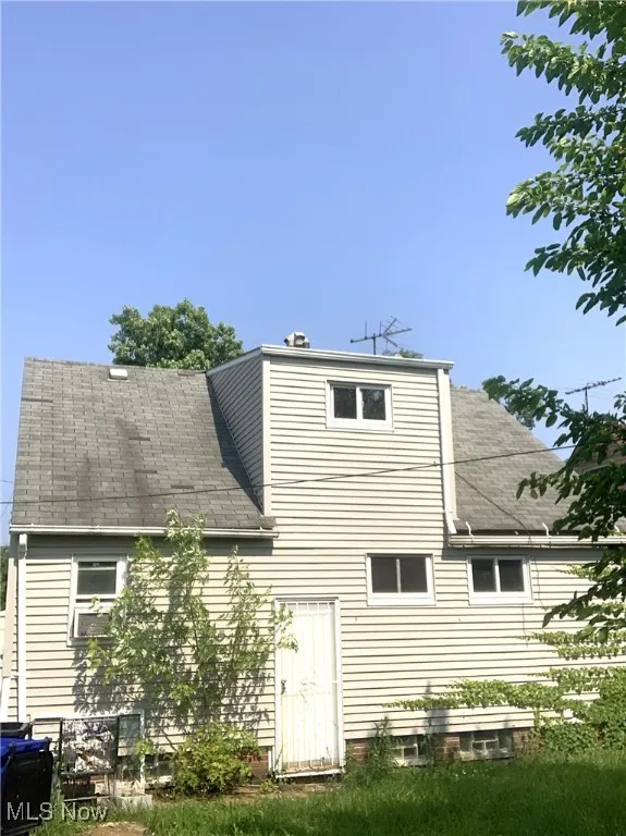 Rear view of property featuring roof with shingles