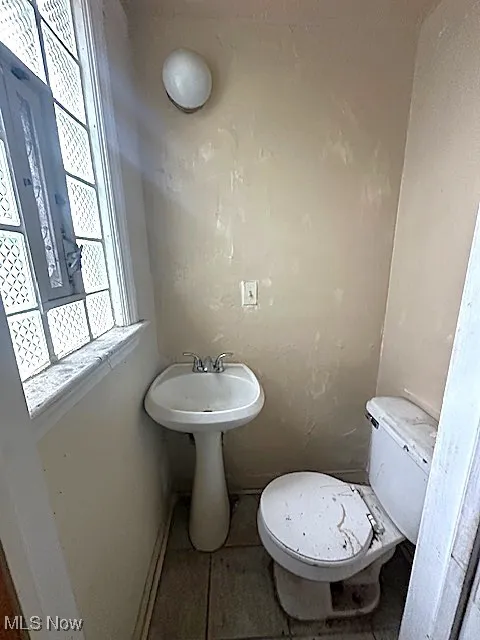 Half bath with toilet and tile patterned flooring