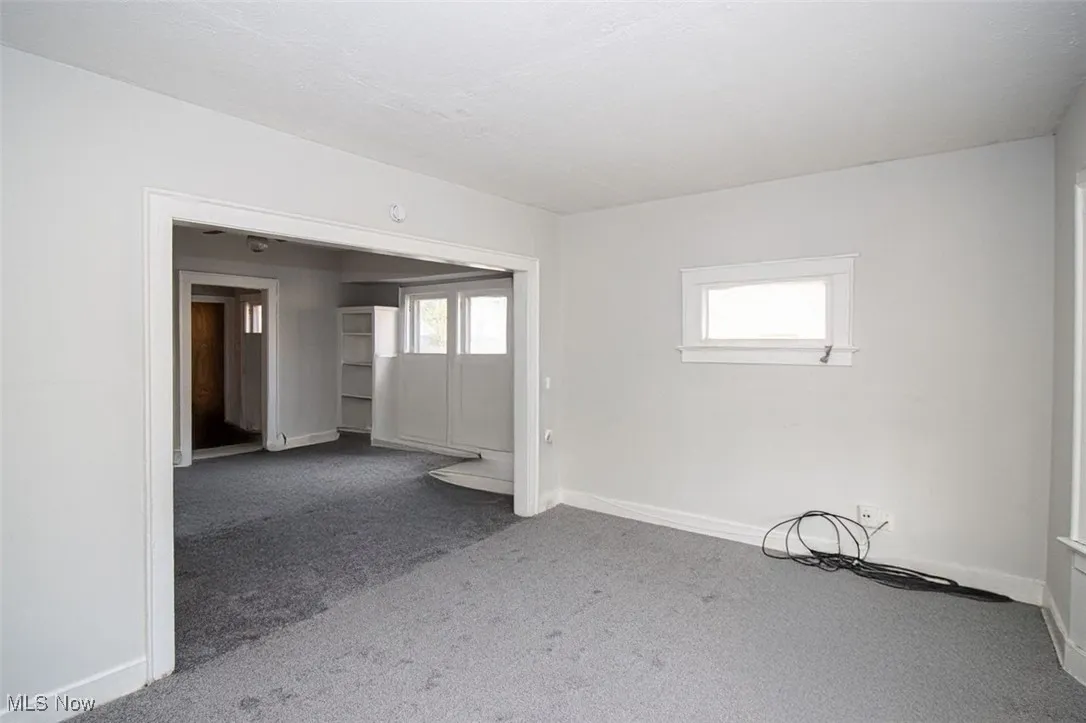 Spare room featuring baseboards and carpet floors