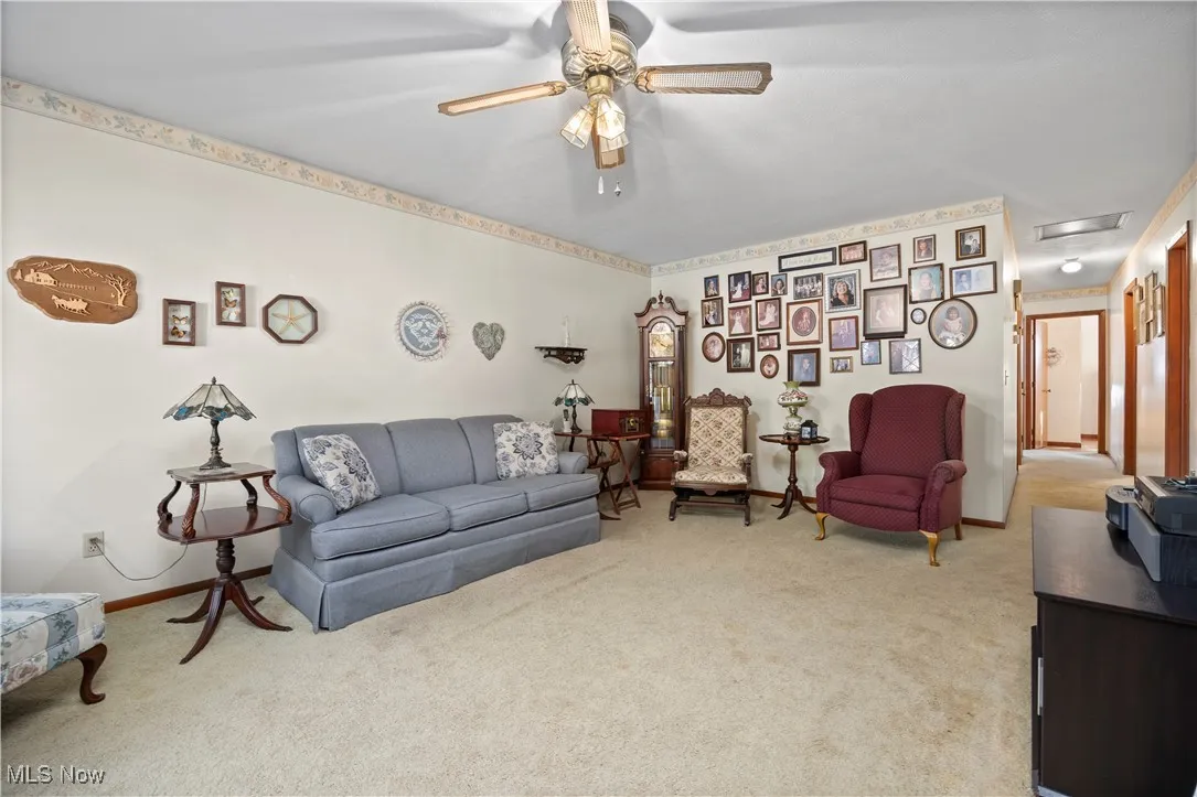 Living room featuring carpet, attic access, and a ceiling fan
