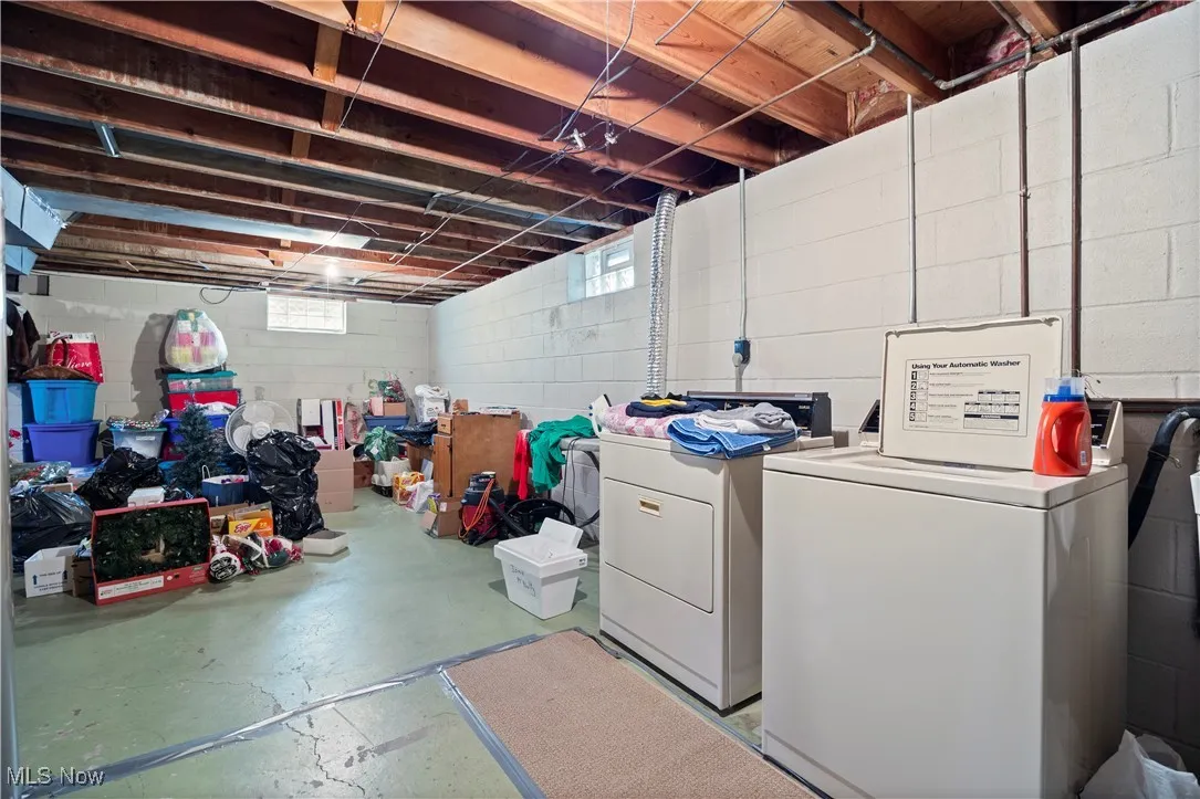 Basement with washing machine and clothes dryer and healthy amount of natural light