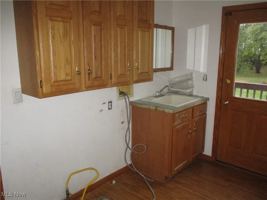 Laundry room featuring healthy amount of natural light, washer hookup, and dark wood-style flooring