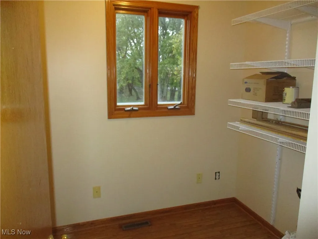 Unfurnished room featuring wood finished floors and baseboards