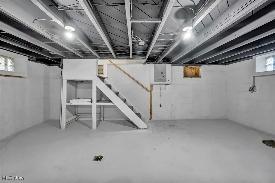 Below grade area featuring stairs and electric panel