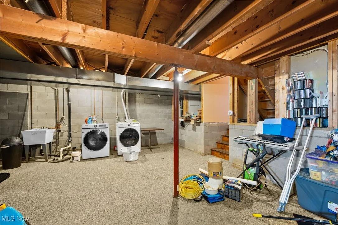 Unfinished basement with stairway and washing machine and dryer