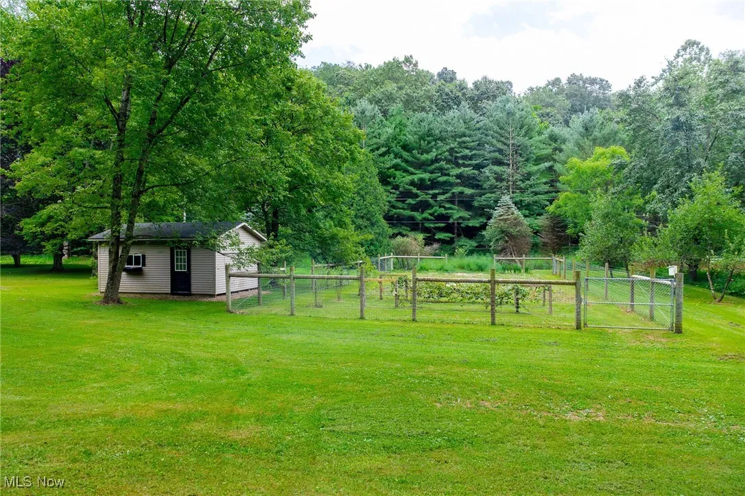 View of yard featuring a gate, an outdoor structure, and a view of countryside
