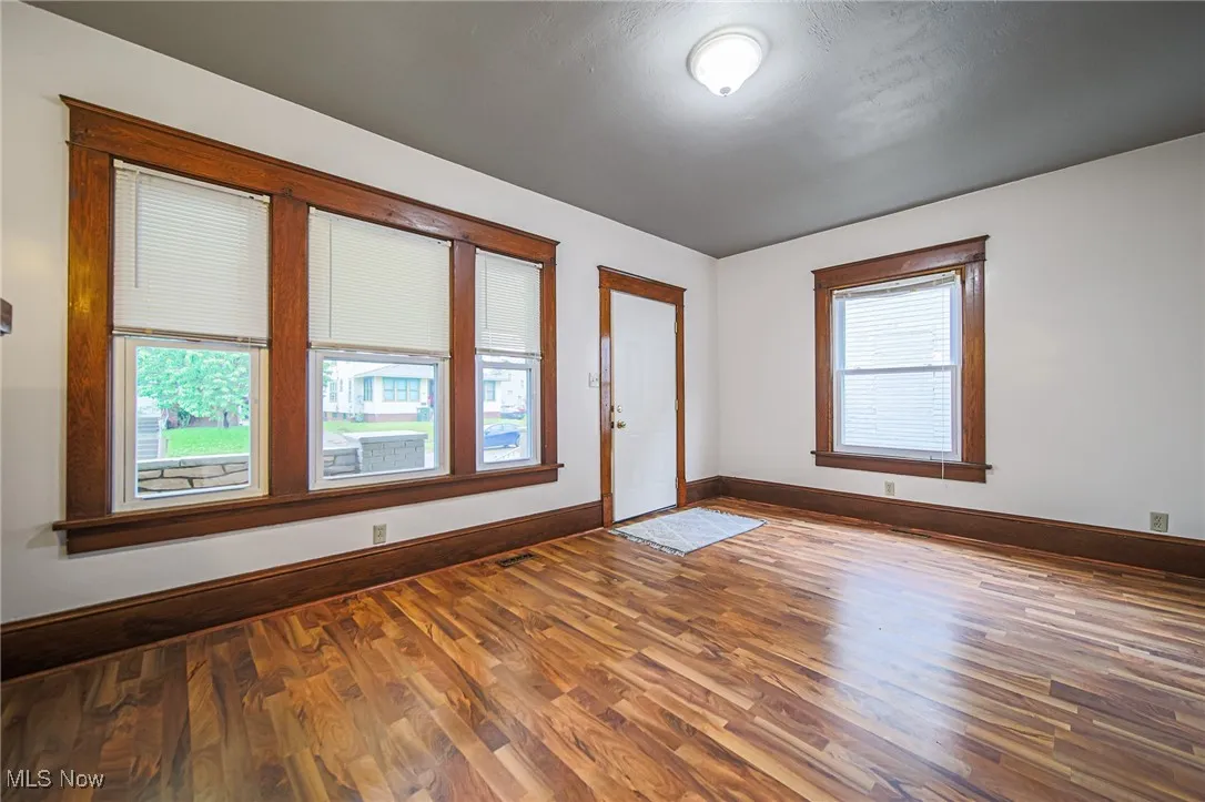 Unfurnished room with wood finished floors and baseboards