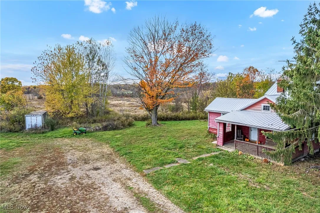 View of grassy yard featuring a porch