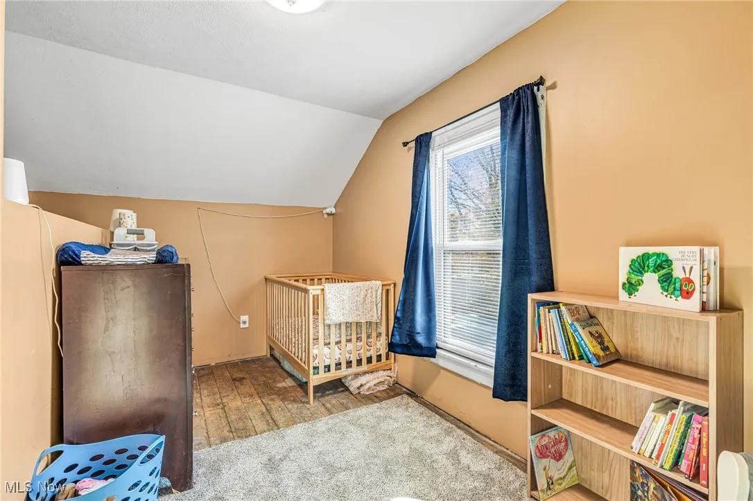 Bedroom#2 featuring lofted ceiling, light carpet, and light wood-style flooring