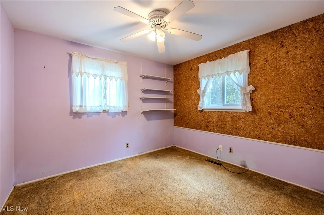 Spare room featuring carpet and a ceiling fan