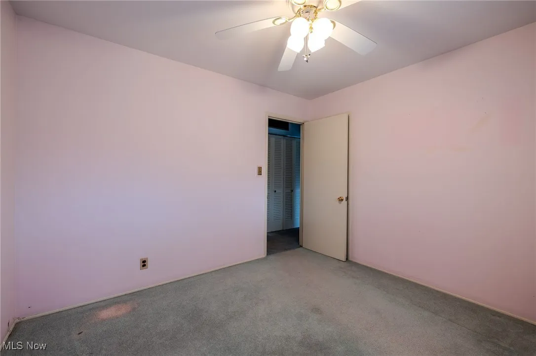 Carpeted empty room with ceiling fan